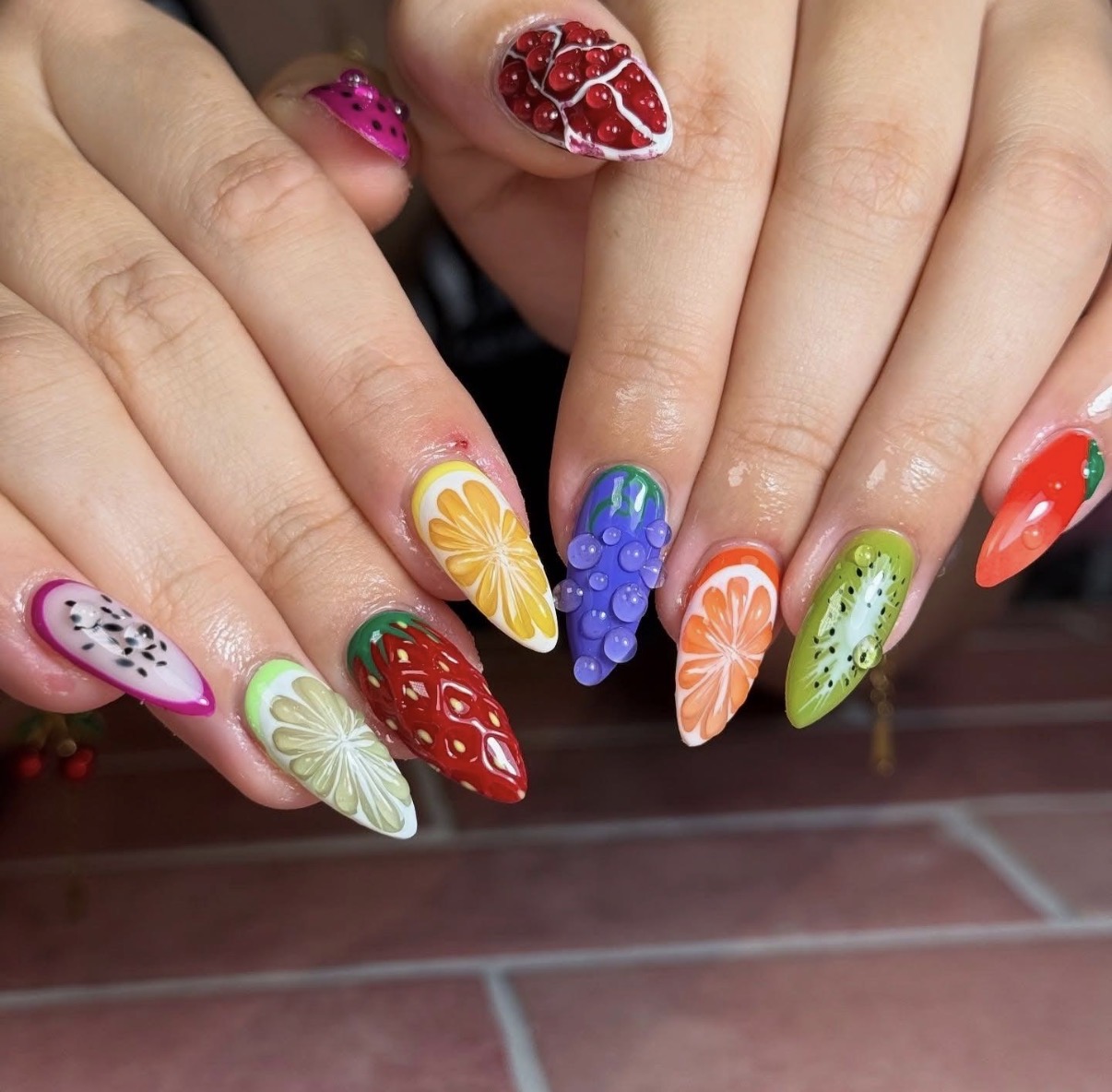 Inspiration : ongles multicolores décorés de fruits et raisins en relief